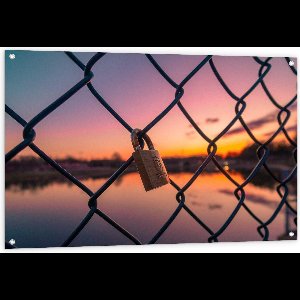 Tuinposter – Slotje aan een Hek met Zonsondergang - 120x80cm Foto op Tuinposter  (wanddecoratie voor buiten en binnen)