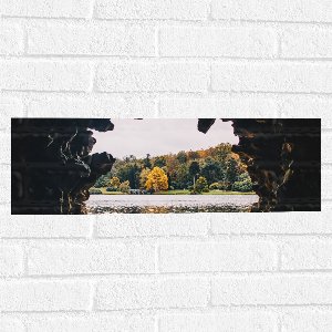 WallClassics - Muursticker - Uitzicht over Meer vanuit een Grot - 60x20 cm Foto op Muursticker