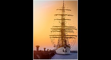 WallClassics - Poster Glanzend – Hoge Mast op Zeilschip bij Zonsondergang - 60x80 cm Foto op Posterpapier met Glanzende Afwerking
