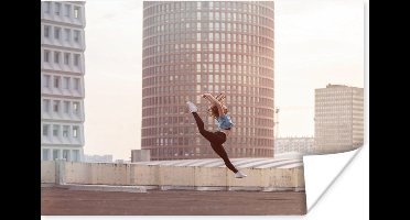 Poster Dansende vrouw op het dak van een gebouw - 30x20 cm