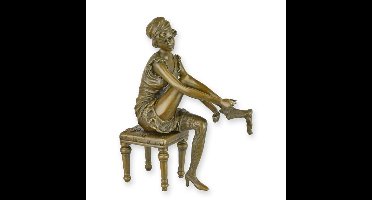 A BRONZE SCULPTURE OF A WOMAN PUTTING ON HER SOCKS