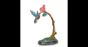 A BRONZE SCULPTURE OF A HUMMING BIRD FEEDING ON A FLOWER